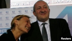 Frontrunner Giorgi Margvelashvili (R) is seen with his partner, Maka Chichua, at the Georgian Dream coalition's headquarters in Tbilisi, October 27, 2013.