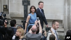 데이비드 캐머런 영국 총리 부부가 23일 영국의 EU 탈퇴 여부를 결정하는 국민투표에 참여한 후 투표장을 떠나고 있다.