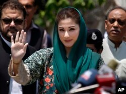 FILE - Maryam Nawaz, center, the daughter of Nawaz Sharif waves while she arrives to talk with media following appearing before a Joint Investigation Team, in Islamabad, Pakistan, July 5, 2017.