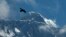 FILE - In this May 27, 2019, file photo, a bird flies with Mount Everest seen in the background from Namche Bajar, Solukhumbu district, Nepal. (AP Photo/Niranjan Shrestha, File)