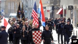 A group of right-wing radicals wave Croatian and US flags as they march through downtown Zagreb, Feb. 26, 2017. 