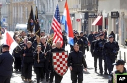 FILE - A group of right-wing radicals wave Croatian and U.S. flags as they march through downtown Zagreb, Feb. 26, 2017.