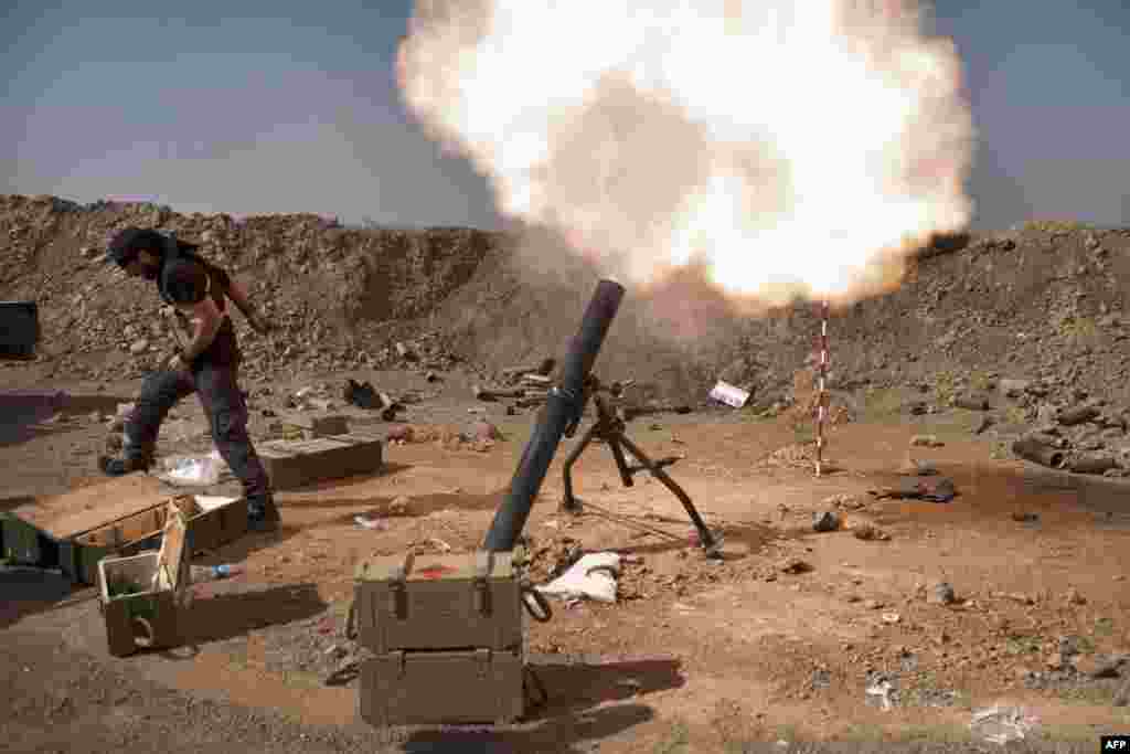 An Iraqi militia fighter from Shi&#39;ite cleric Moqtada al-Sadr&#39;s Saraya al-Salam&#39;s Peace Brigade, fires a mortar during heavy clashes with Islamic State fighters in Tuz Khurmatu in Salaheddin province about 88 kilometres (55 miles) south of Kirkuk.