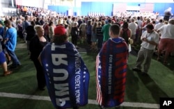 Brien Wedlock, right, and Matt Catanzaro are pretty much ignored as they wear Donald trump capes at a campaign rally for Democratic presidential candidate Hillary Clinton, in Scranton, Pa., Aug. 15, 2016.