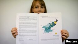 Sarah Son, research director of Transitional Justice Working Group, holds a graphic showing suspected killing sites in North Korea, during an interview in Seoul, South Korea, July 19, 2017.