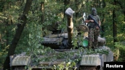 A pro-Russian separatist poses for a picture atop a T-64 tank in Donetsk, eastern Ukraine, July 16, 2014.