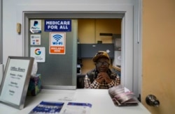 Jerome Anderson sits behind a window in a clinic where he distributes Narcan and other medical supplies in St. Louis on Wednesday, May 19, 2021. (AP Photo/Brynn Anderson)