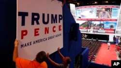 Workers place a sign as they prepare at Quicken Loans Arena for the Republican National Convention, Sunday, July 17, 2016.