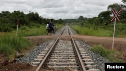 A man rides a bike over a railway line in Moatize in Tete province February 13, 2013. The Renamo opposition party is threatening to paralyze the Mozambique railway that transports coal to the coast for export.