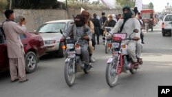 FILE - Taliban fighters ride their motorbikes inside Ghazni city, west of Kabul, Afghanistan, June 16, 2018.