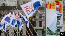 FILE - Flags of the Dutch EU presidency and posters for a non-binding referendum on the EU-Ukraine association agreement are seen in The Hague, Netherlands, April 6, 2016. The resulting "no" vote was greeted with concern in the West, but with delight in Moscow.