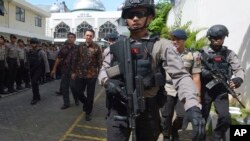 Gubernur nonaktif Jakarta Basuki "Ahok" Tjahaja Purnama, dikawal polisi anti-teror saat meninggalkan Pengadilan Jakarta Utara (20/12). (AP/Adek Berry)