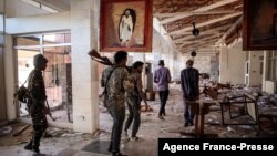 FILE - Amhara Fano militia fighters walk through a ransacked building at the airport in Lalibela, Ethiopia, Dec. 7, 2021. In August 2023, months of fighting between the federal government and Fano forces reached its peak, leading to a shortage of goods in the Amhara region.