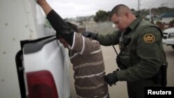 Un agente de la patrulla fronteriza detiene a un indocumentado en San Ysidro, California. 