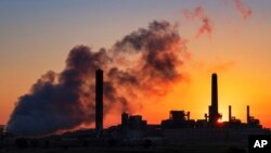 FILE - In this July 27, 2018, file photo, the Dave Johnson coal-fired power plant is silhouetted against the morning sun in Glenrock, Wyoming. (AP Photo/J. David Ake, File)