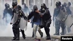 Police help a pedestrian overcome by tear gas as supporters of Salvador Nasralla, presidential candidate for the Opposition Alliance Against the Dictatorship, clash with police during a protest caused by the delayed presidential vote count, Dec. 1, 2017.