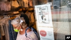 Foto de archivo. Un cliente con una máscara sale de una tienda en Broadway, el viernes 14 de mayo de 2021.