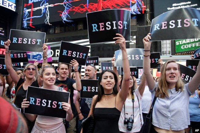 FILE - Protesters gather in Times Square, July 26, 2017, in New York, where a rally was held after President Donald Trump's announcement of a ban on transgender troops serving anywhere in the U.S. military.
