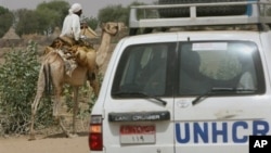 UNHCR convoy passes Sudanese man riding on a camel, Um Shalaya refugee camp south of the Darfur town of Al-Geneina, April 25, 2007 file photo.