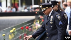 Un policier rend hommage aux victimes à l’occasion du 17e anniversaire des attentats terroristes du 11 Septembre au mémorial de Ground, New York, 11 septembre 2018.