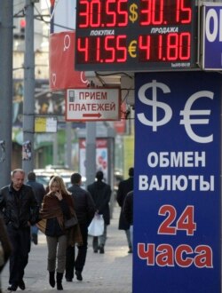 FILE - People walk past an exchange booth in a street in Moscow, Russia, Thursday, Sept. 30, 2010. Russia's Central Bank has ordered to close all exchange booths outside banks starting Oct. 1, 2010. (AP Photo/Mikhail Metzel)