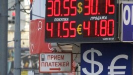FILE - People walk past an exchange booth in a street in Moscow, Russia, Thursday, Sept. 30, 2010. Russia's Central Bank has ordered to close all exchange booths outside banks starting Oct. 1, 2010. (AP Photo/Mikhail Metzel)