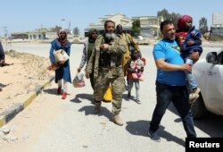 Members of Libyan internationally recognised government forces evacuate a family during the fighting with Eastern forces, at Al-Swani area in Tripoli, Libya, April 18, 2019.