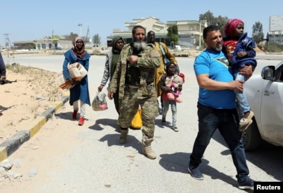 Members of Libyan internationally recognised government forces evacuate a family during the fighting with Eastern forces, at Al-Swani area in Tripoli, Libya, April 18, 2019.