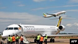 Abakozi ba Ouganda Airlines ku kibuga c'indege ca d’Entebbe mu bikorwa vyo gusubira gutangura gutwara ingenzi.