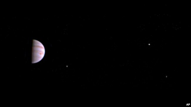 This July 10, 2016, image released by NASA was taken by the Juno spacecraft, five days after it arrived at Jupiter. The image shows Jupiter's Great Red Spot and three of its four largest moons. (Juno/NASA/JPL-Caltech/SwRI/MSSS via AP)