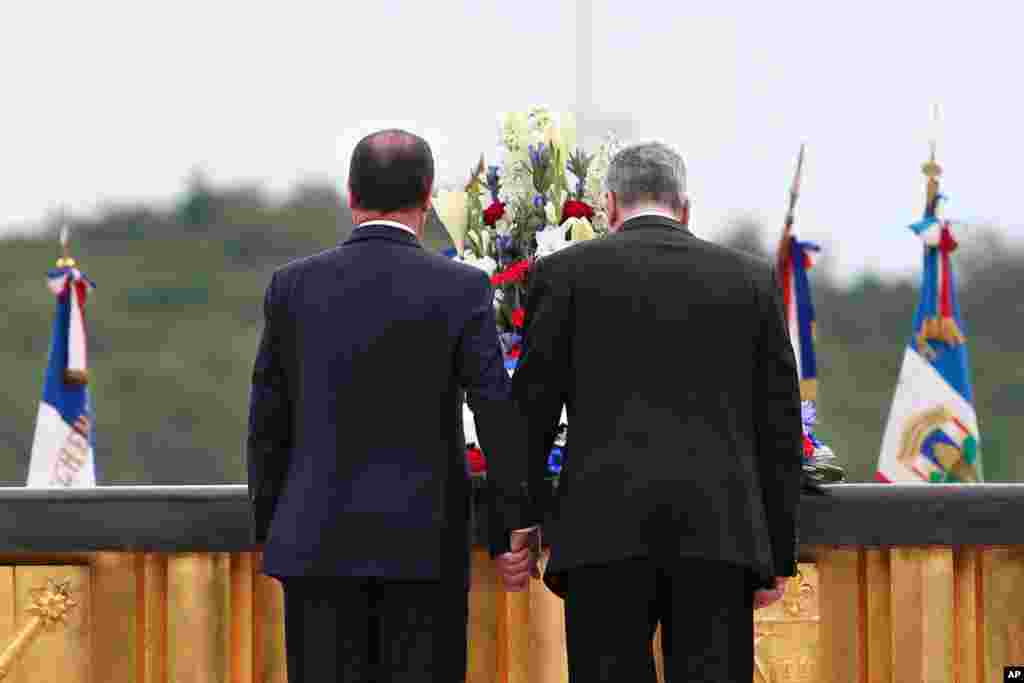 French President Francois Hollande (left) and German President Joachim Gauck pay their respects during a ceremony to mark the 100th anniversary of the outbreak of World War I, at the National Monument of Hartmannswillerkop, in Wattwiller, eastern France, Aug. 3, 2014.