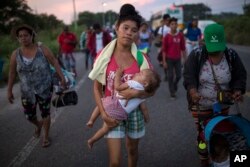 Dvadeset-dvogodišnja Maria Gomes nosi jednogodišnjeg sina Davida Moisesa, u kravanu migranata iz Centralne Amerike, koji je trenurno blizu Jučitana, u Mekisku (Foto: AP)