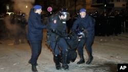 Policajci nose povređenog kolegu pred američkom ambasadom tokom protesta "Kosovo je Srbija"