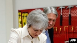 La première ministre britannique Theresa May (à gauche) et le ministre des finances, Philip Hammond (à droite), le 1er octobre 2018. / AFP PHOTO / POOL / DARREN STAPLES