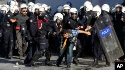 Turkish riot police detain protesters rallying against what they see as Turkey's inaction against Islamic State militants moving against Kurds in Syria, close to Turkey's border, in Ankara, Oct. 7, 2014.