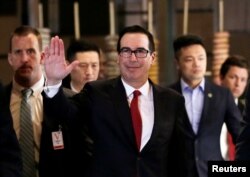 U.S. Treasury Secretary Steven Mnuchin, a member of the U.S. trade delegation to China, waves to the media as he returns to a hotel in Beijing, May 3, 2018.