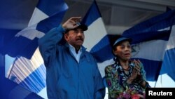 FILE - Nicaraguan President Daniel Ortega and Vice President Rosario Murillo gesture during a march called 'We walk for peace and life. Justice' in Managua, Nicaragua, Sept. 5, 2018. 