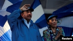 FILE - Nicaraguan President Daniel Ortega and Vice President Rosario Murillo gesture during a march called 'We walk for peace and life. Justice' in Managua, Nicaragua, Sept. 5, 2018.