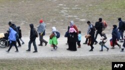 Les migrants se rendent au premier point d'enregistrement de la police fédérale allemande après avoir franchi le pont frontalier germano-autrichien du sud de l'Allemagne, le 27 octobre 2015.