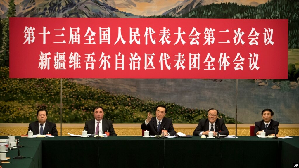 2019年3月12日在北京人民大会堂举行的全国人大会议新疆维吾尔自治区代表团会议上，新疆党委书记陈全国（中）讲话。讲台上的人前面都没有名牌。(photo:VOA)