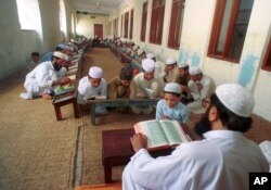 FILE - An undated photo of Pakistani children studying the Quran at a religious school in Lahore, Pakistan.