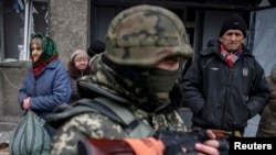 Local residents wait for a bus to flee the conflict in Debaltseve, eastern Ukraine, Feb. 5, 2015. 