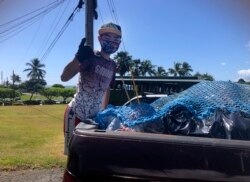Genshu Price berdiri di belakang truk setelah memuatnya dengan kaleng dan botol daur ulang dari Kualoa Ranch di Kāne'ohe, Hawaii, untuk penggalangan dana "Bottles4College", Mei 2021. (Maria PRice/ Bottles4College via AP)
