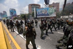 Bolivarian National Guard officers advance towards demonstrators during a protest in Caracas, Venezuela, April 10, 2017.