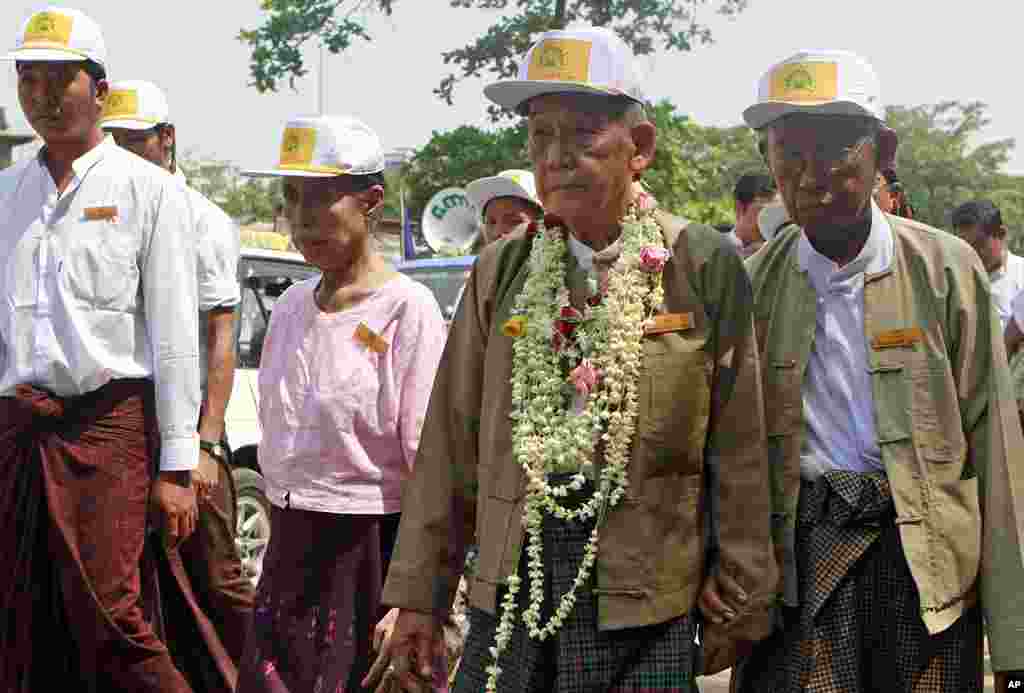 Thu Wai, second from right, chairman of Democratic Party, walks along with his party's members during an election campaign in a township in Rangoon, March 23, 2012. (AP)
