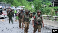 EDITORS NOTE: Graphic content / Armed government troops cross a bomb damaged bridge outside the compound of the Gote Twin police station in Shan State on August 15, 2019, after it was attacked by ethnic rebel groups. - At least 14 have been killed in ongo
