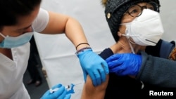 A healthcare worker administers a shot of the Moderna COVID-19 Vaccine to a woman at a pop-up vaccination site operated by SOMOS Community Care during the coronavirus disease (COVID-19) pandemic in Manhattan in New York City, New York, U.S., January 29, 2