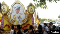 ผู้ชุมนุมเดินผ่านซุ้มพระบรมฉายาลักษณ์พระบาทสมเด็จพระเจ้าอยู่หัว รัชกาลที่ 10 เมื่อ 26 กรกฎาคม 2020 (ที่มา: รอยเตอร์)