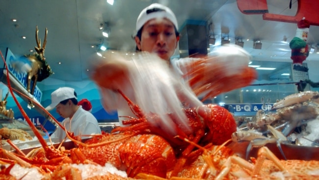 资料照：澳大利亚悉尼海鲜市场的一名商贩在展示他烹饪的龙虾。