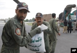 Pakistani soldiers load relief goods to a plane for earthquake victims, in Peshawar, Pakistan, Oct. 27, 2015.